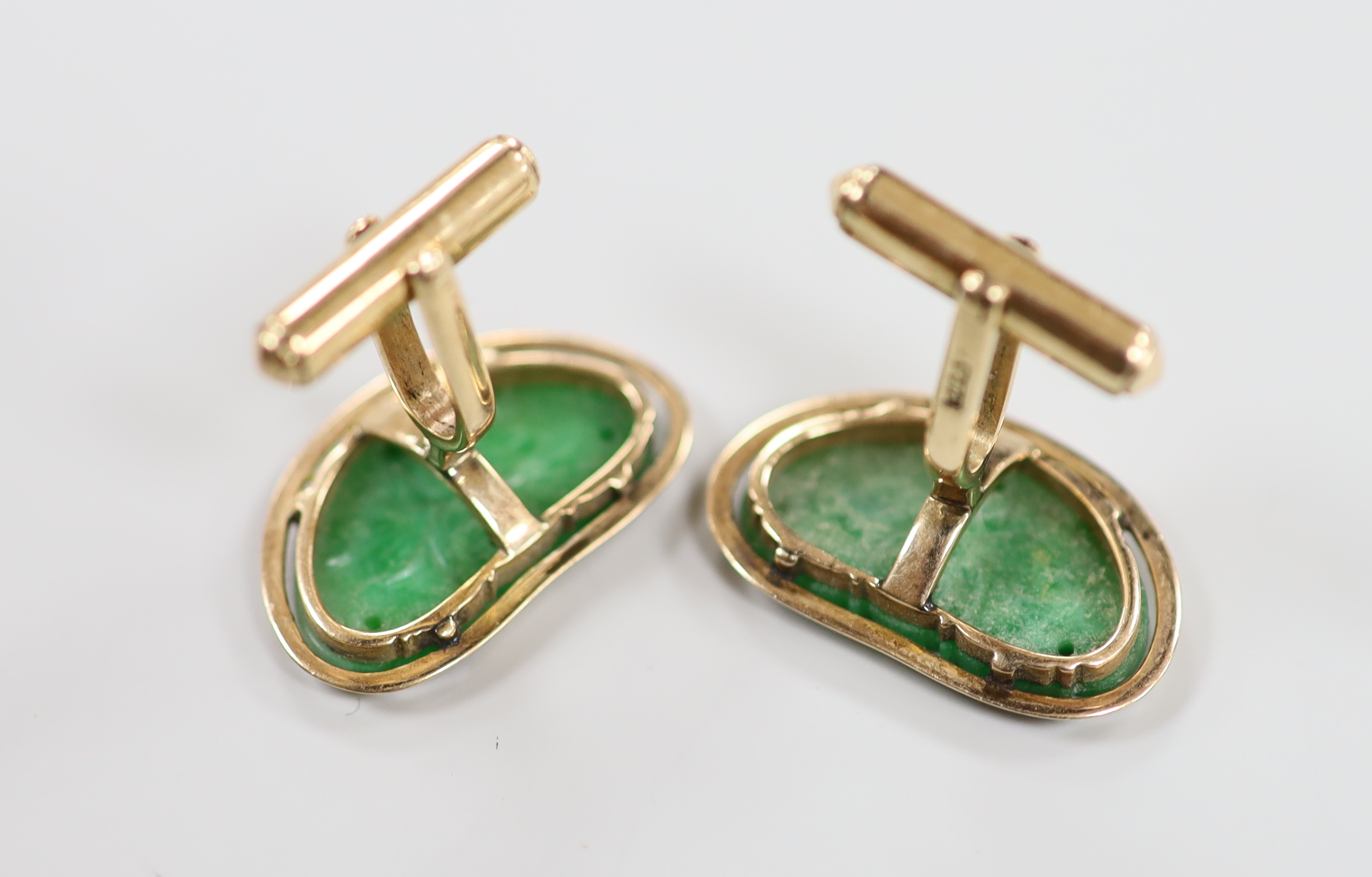 A pair of Chinese yellow metal mounted carved green jade cufflinks, 23mm, together with a further pair of planished yellow metal cufflinks, gross weight 15.3 grams.